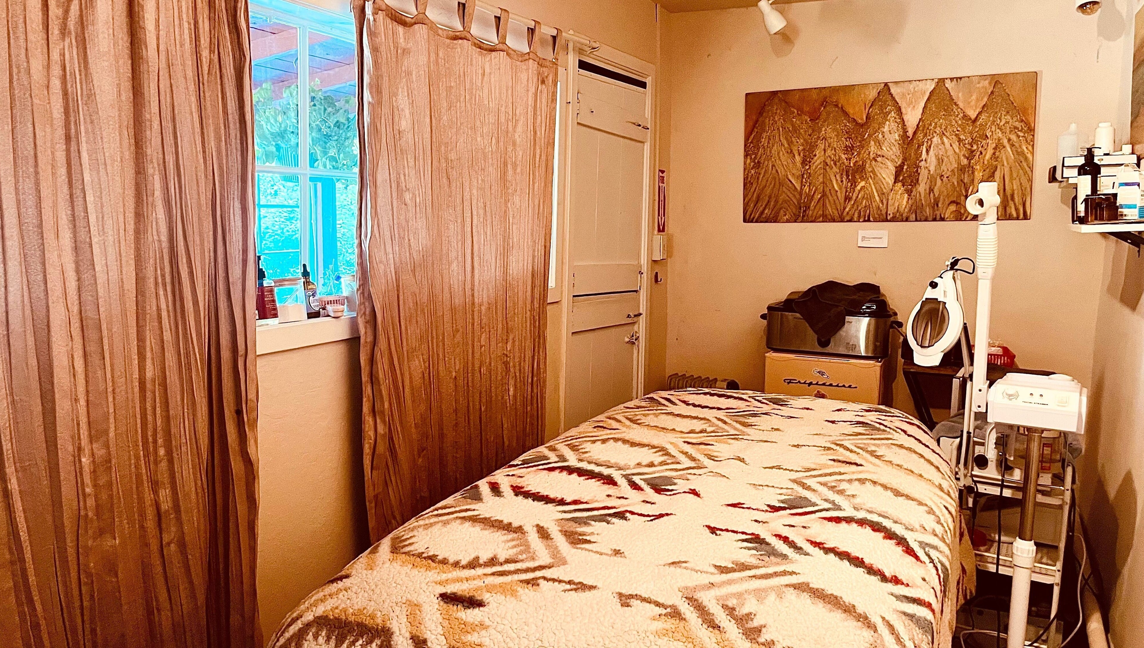 Cozy therapy room at Adorn Apothecary, Aptos, California, US with a massage table and soothing decor.