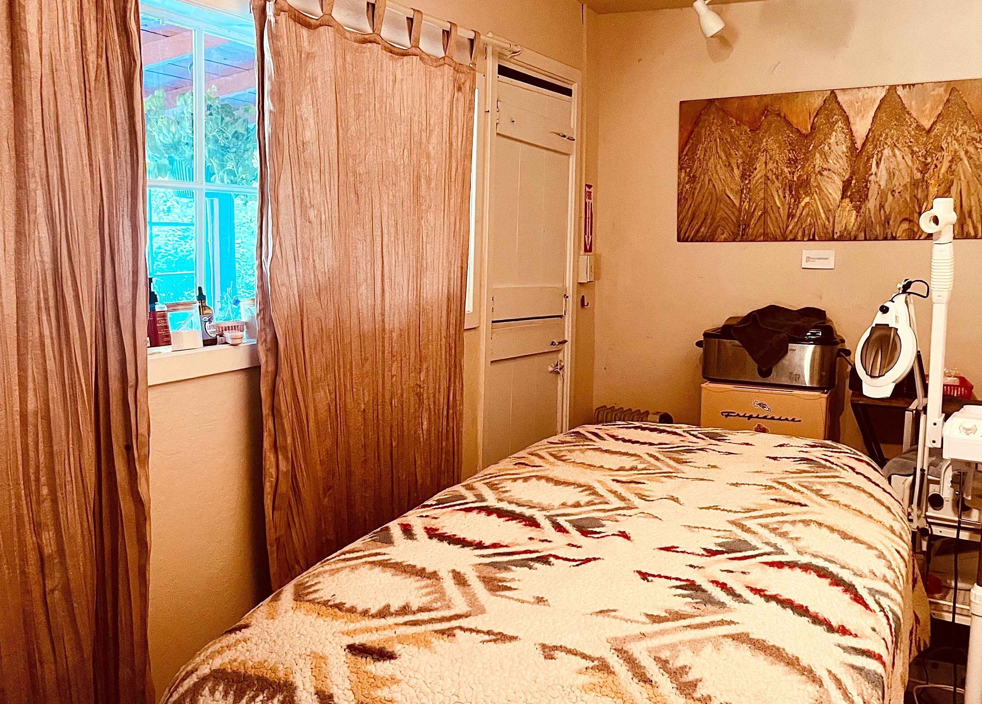 Cozy therapy room at Adorn Apothecary, Aptos, California, US with a massage table and soothing decor.