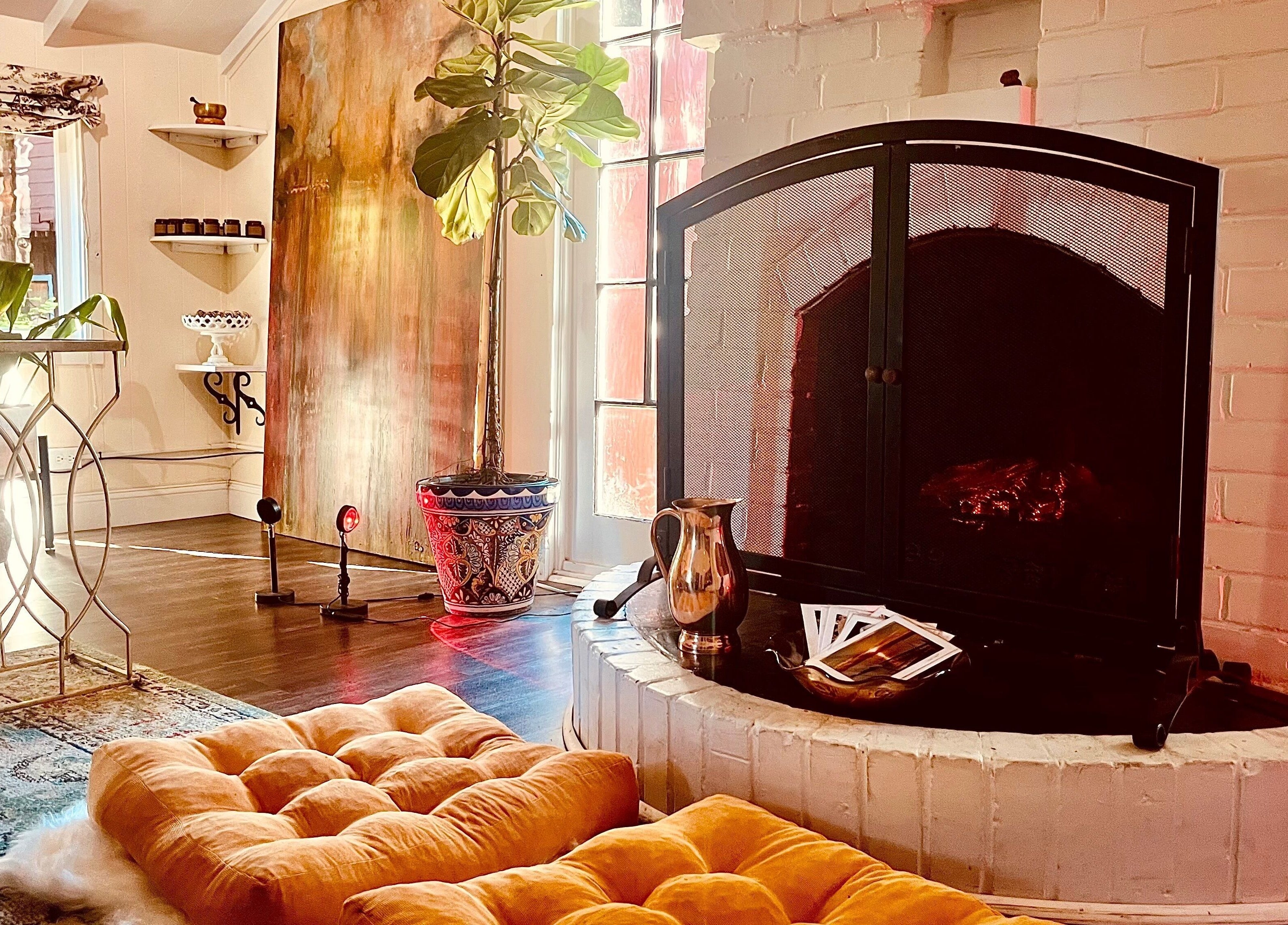 Inviting lounge with plush seating and fireplace at Adorn Apothecary, Aptos, California, US.