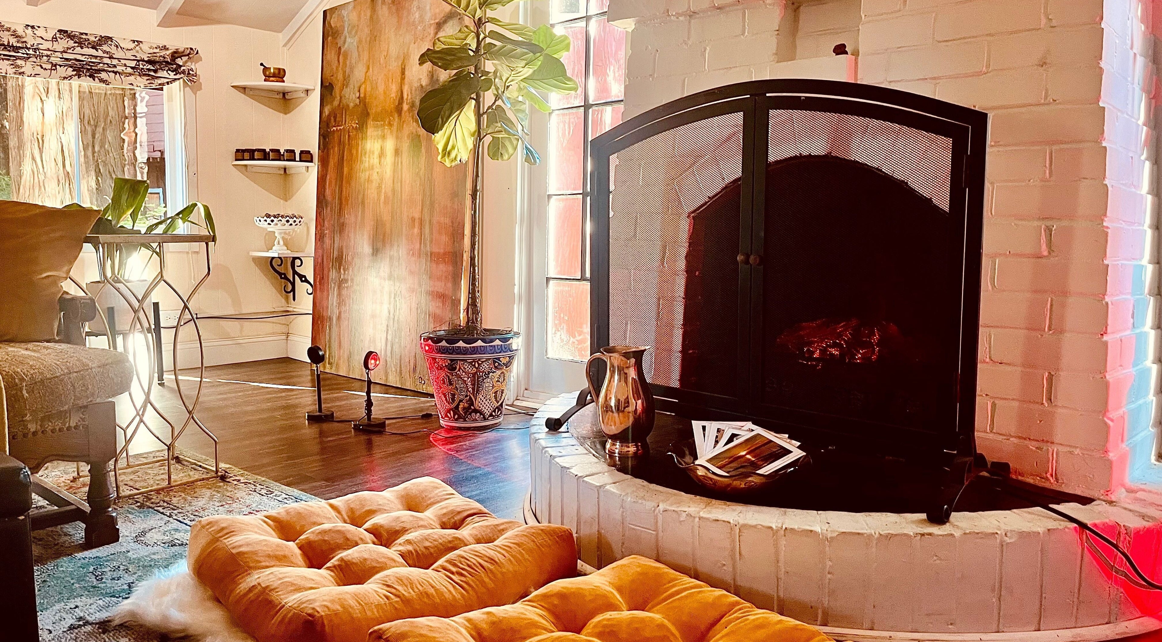 Inviting lounge with plush seating and fireplace at Adorn Apothecary, Aptos, California, US.