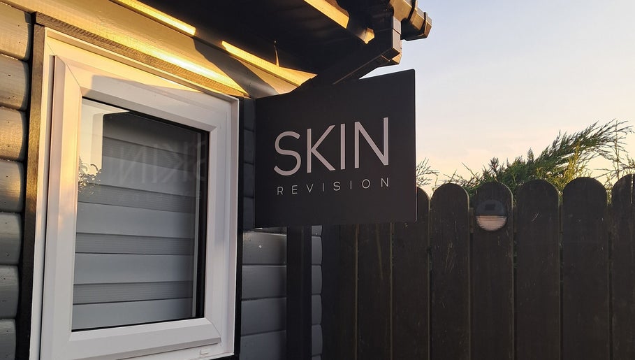 Skin Revision storefront sign in Douglas, IM, featuring a sleek design under soft evening light.