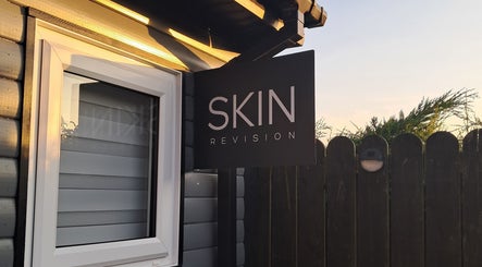 Skin Revision storefront sign in Douglas, IM, featuring a sleek design under soft evening light.