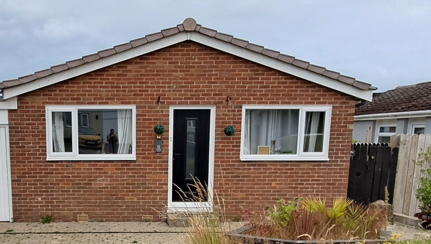 Skin Revision Douglas, IM features a cozy red brick exterior with large windows and a welcoming entrance.