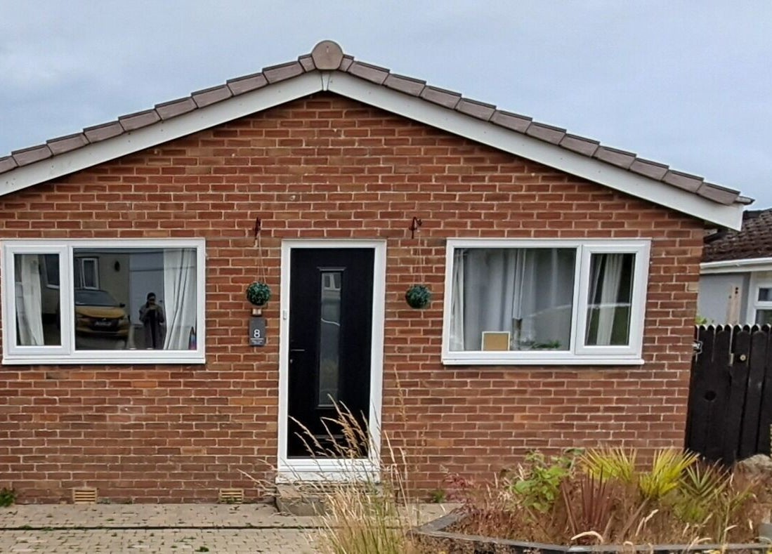 Skin Revision Douglas, IM features a cozy red brick exterior with large windows and a welcoming entrance.