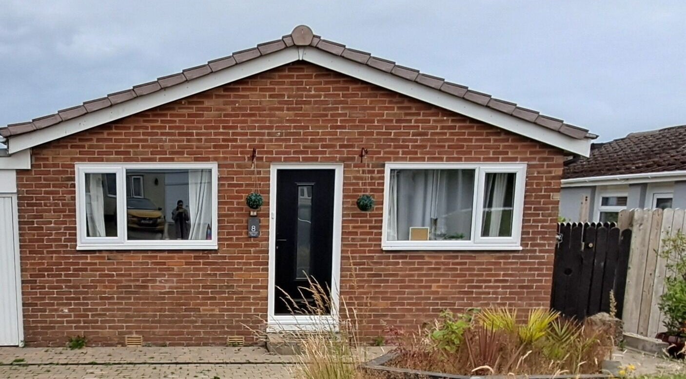 Skin Revision Douglas, IM features a cozy red brick exterior with large windows and a welcoming entrance.