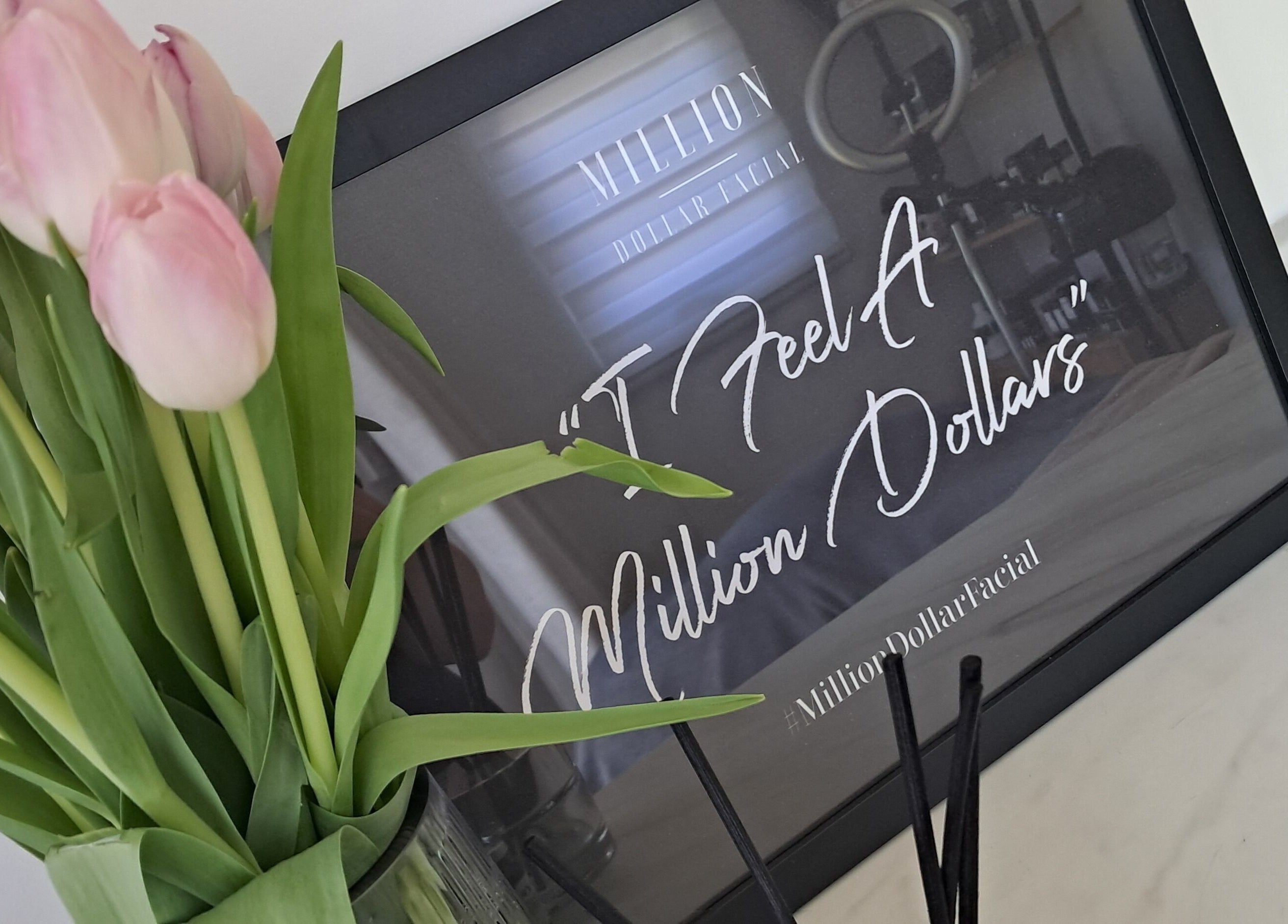 Elegant tulips beside a framed quote at Skin Revision, Douglas, IM, creating a luxury wellness ambiance.