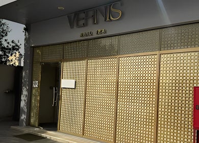 Elegant entrance of Vernis Nail Spa - Al Nakheel Branch, Riyadh, SA featuring a golden facade.