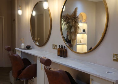 Lux - Cathcart's elegant styling chairs in Glasgow, Scotland, GB with round mirrors reflecting warm, inviting decor.