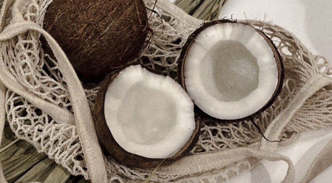 Coconut halves in natural fibers at Aura Aesthetics Studio, Cessnock, AU, symbolizing relaxation.