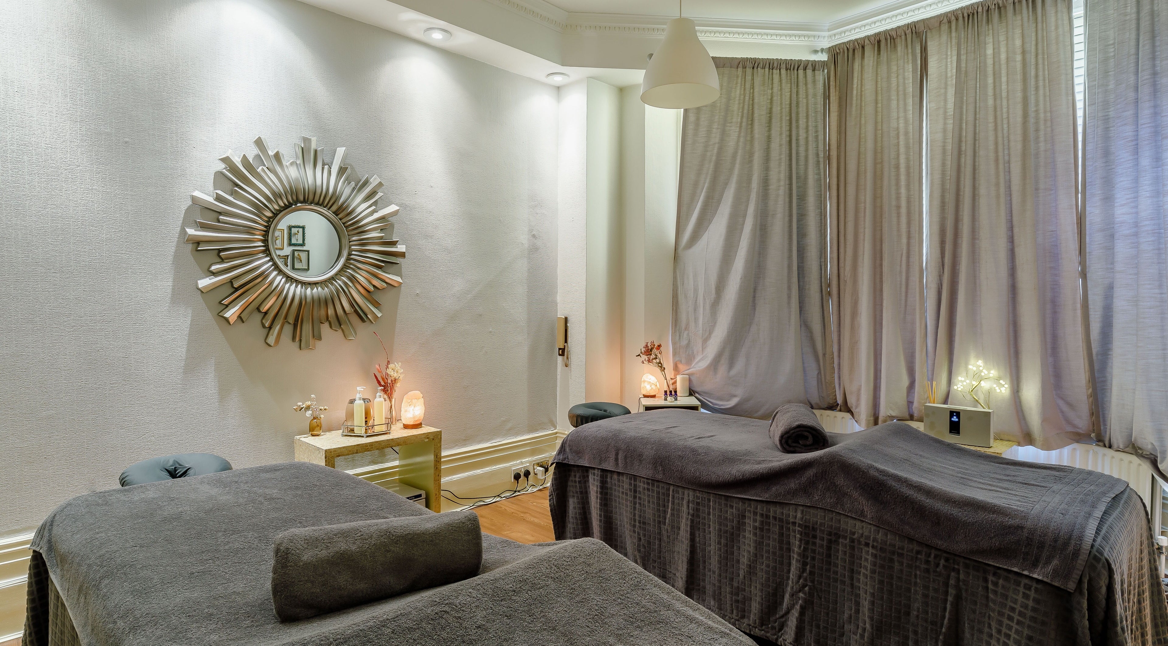 Revive Massage Studios in London, England, GB features a tranquil massage room with elegant decor and soothing lighting.