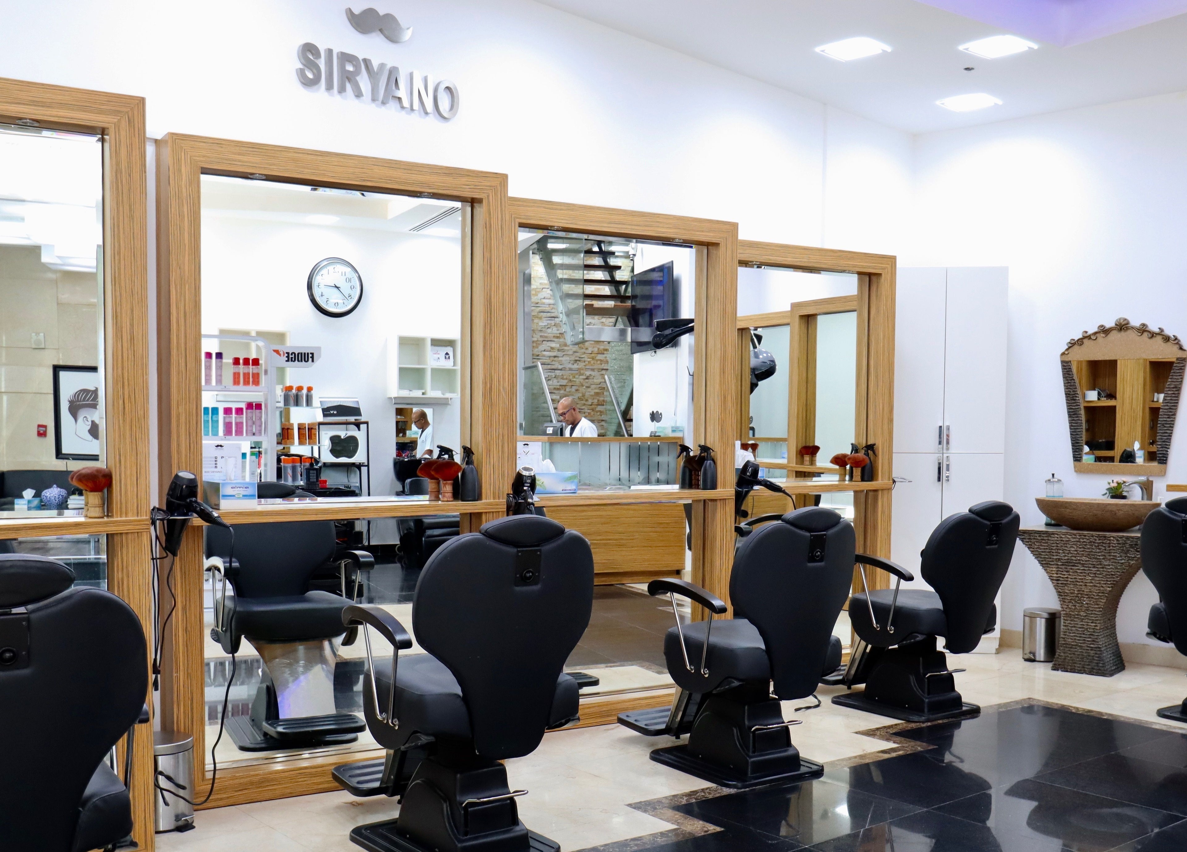 Chic interior of Siryano Gents Saloon and Spa, Escape Tower in Dubai, AE featuring sleek black chairs and wooden accents.