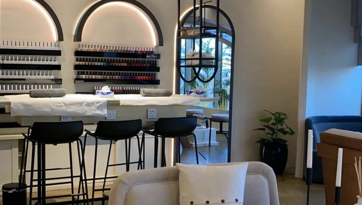 Elegant interior of Base Coat Nail Spa in Jeddah, Makkah Province, SA with stylish seating and polish display.