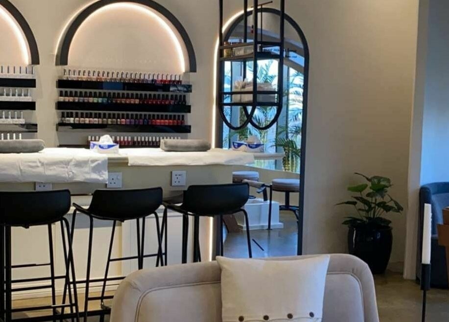 Elegant interior of Base Coat Nail Spa in Jeddah, Makkah Province, SA with stylish seating and polish display.