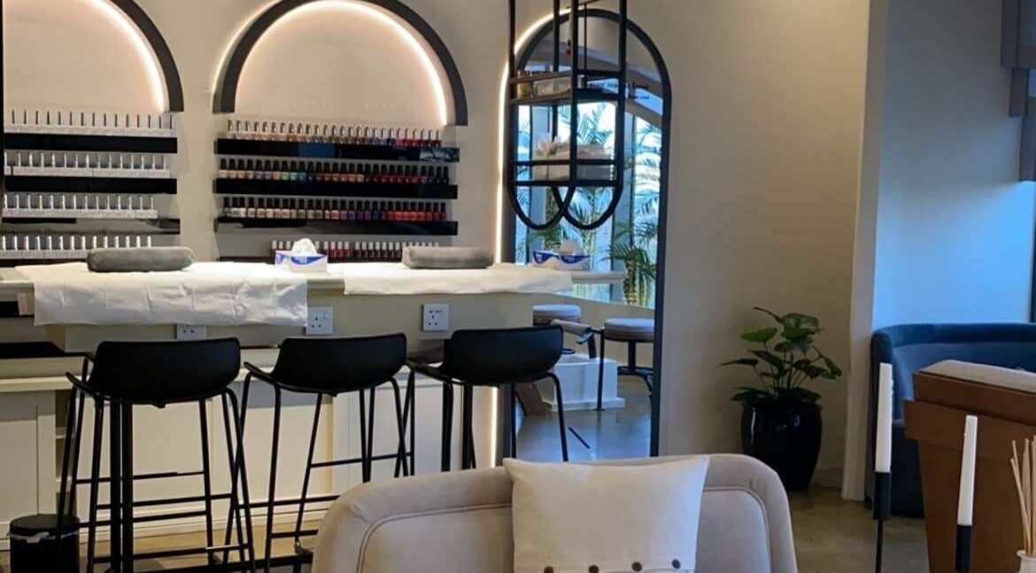 Elegant interior of Base Coat Nail Spa in Jeddah, Makkah Province, SA with stylish seating and polish display.