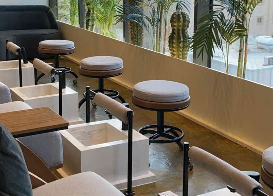 Comfortable pedicure seating at Base Coat Nail Spa in Jeddah, Makkah Province, SA with lush greenery.