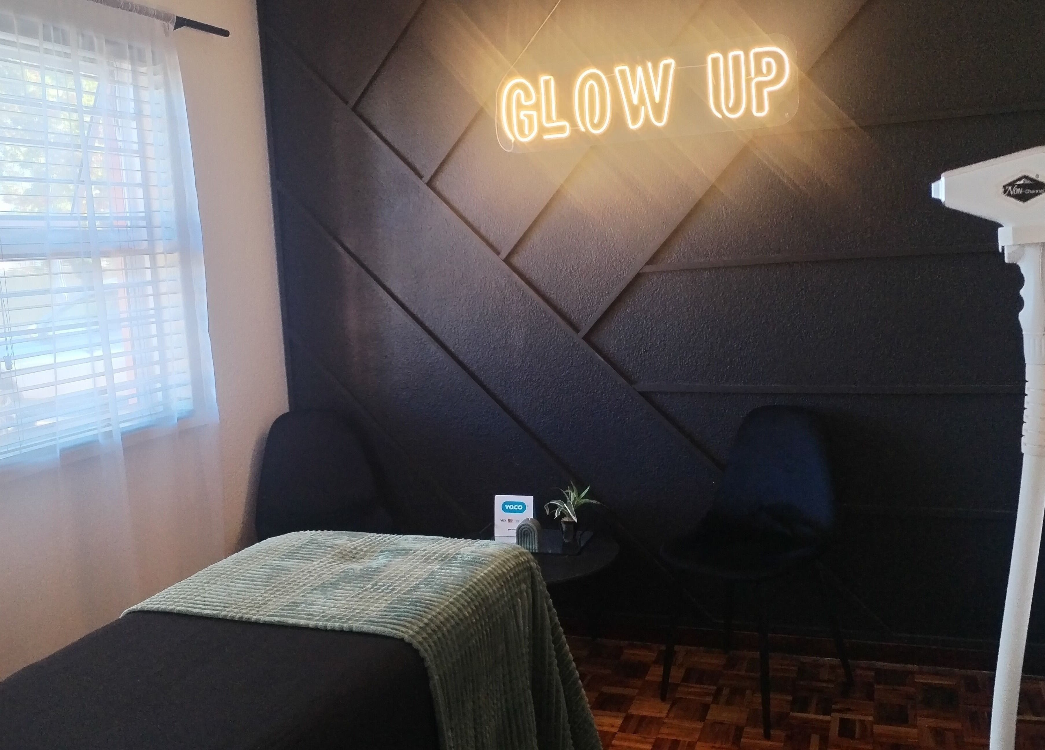 Elegant treatment room at Bare & Blink, Cape Town, Western Cape, ZA with 'Glow Up' sign and modern decor.
