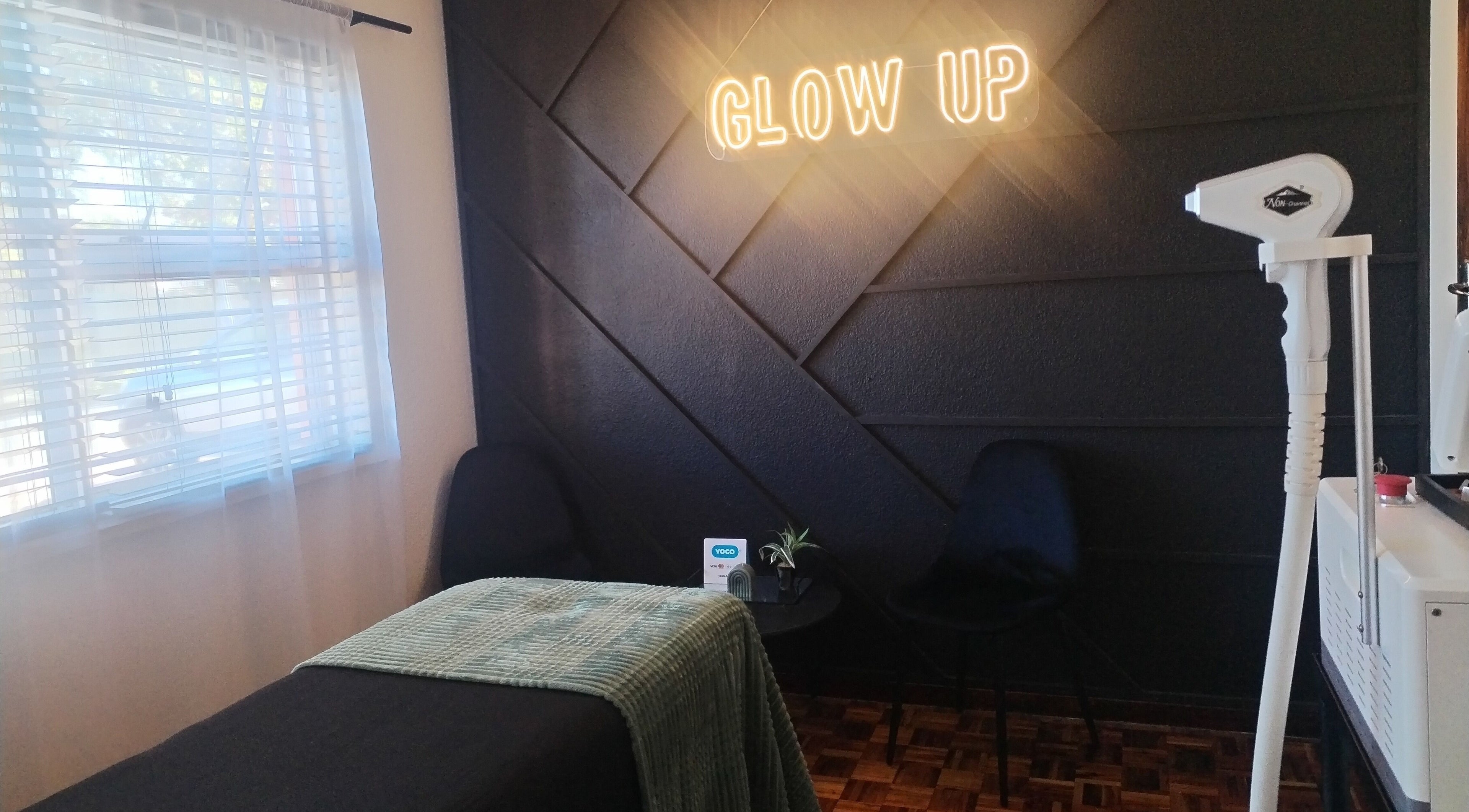 Elegant treatment room at Bare & Blink, Cape Town, Western Cape, ZA with 'Glow Up' sign and modern decor.