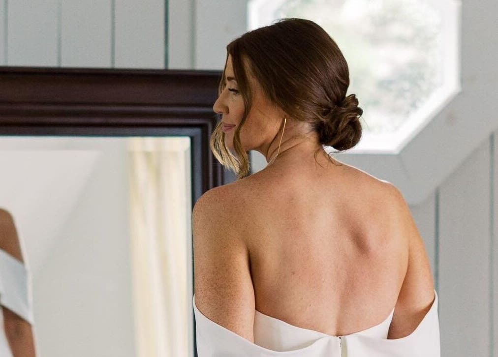 Woman in white dress looks at reflection, All Tan Everything, Halifax, Nova Scotia, CA.