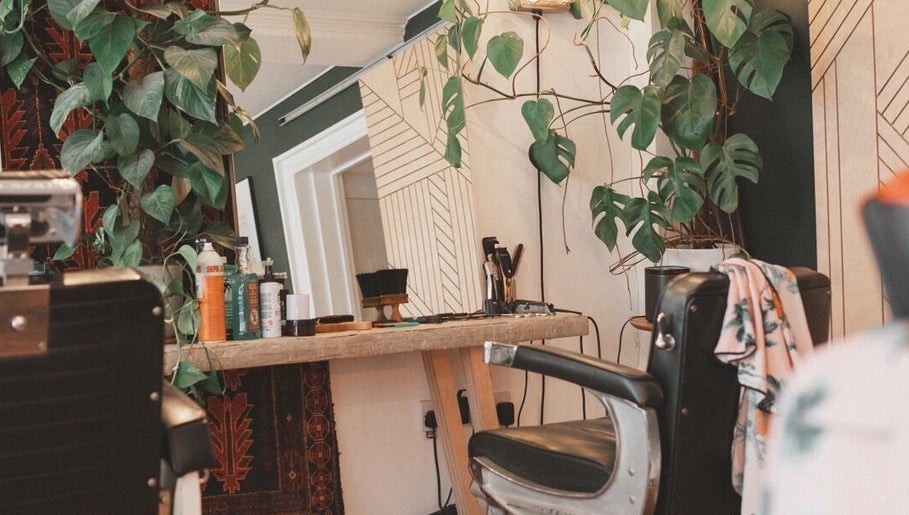 Chic salon chair and mirror at Courage Noble | King Street, Norfolk, England, GB with lush plants.