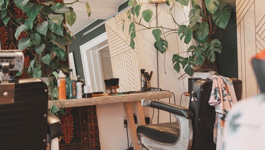 Chic salon chair and mirror at Courage Noble | King Street, Norfolk, England, GB with lush plants.