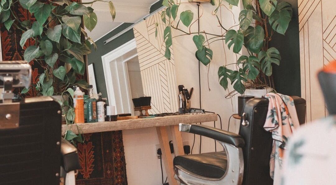 Chic salon chair and mirror at Courage Noble | King Street, Norfolk, England, GB with lush plants.