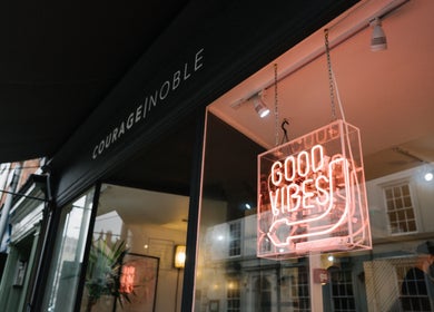 Entrance of Courage Noble | King Street, Norwich, England, GB with neon 'Good Vibes' sign.
