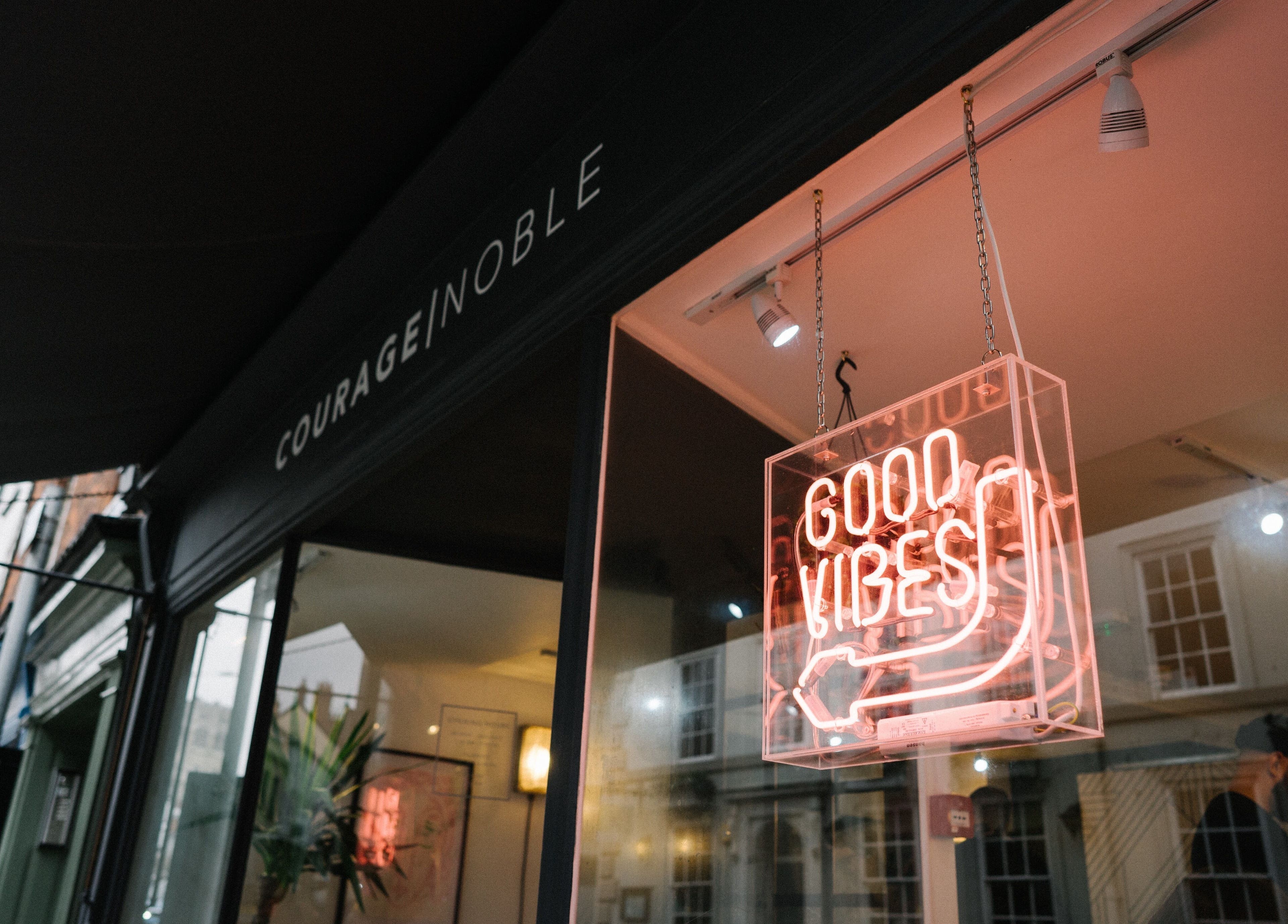Entrance of Courage Noble | King Street, Norwich, England, GB with neon 'Good Vibes' sign.