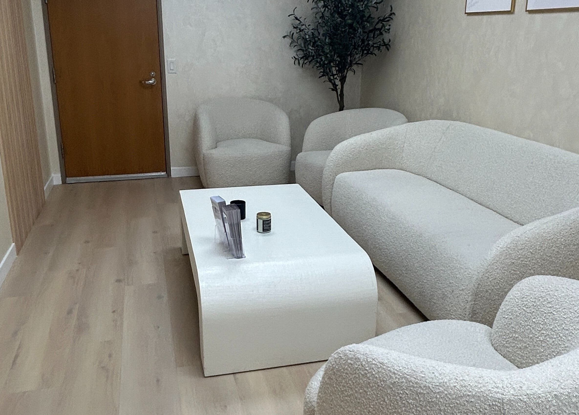 Comfortable waiting area at Skinsation LA, Los Angeles, California, US, featuring plush white seating.