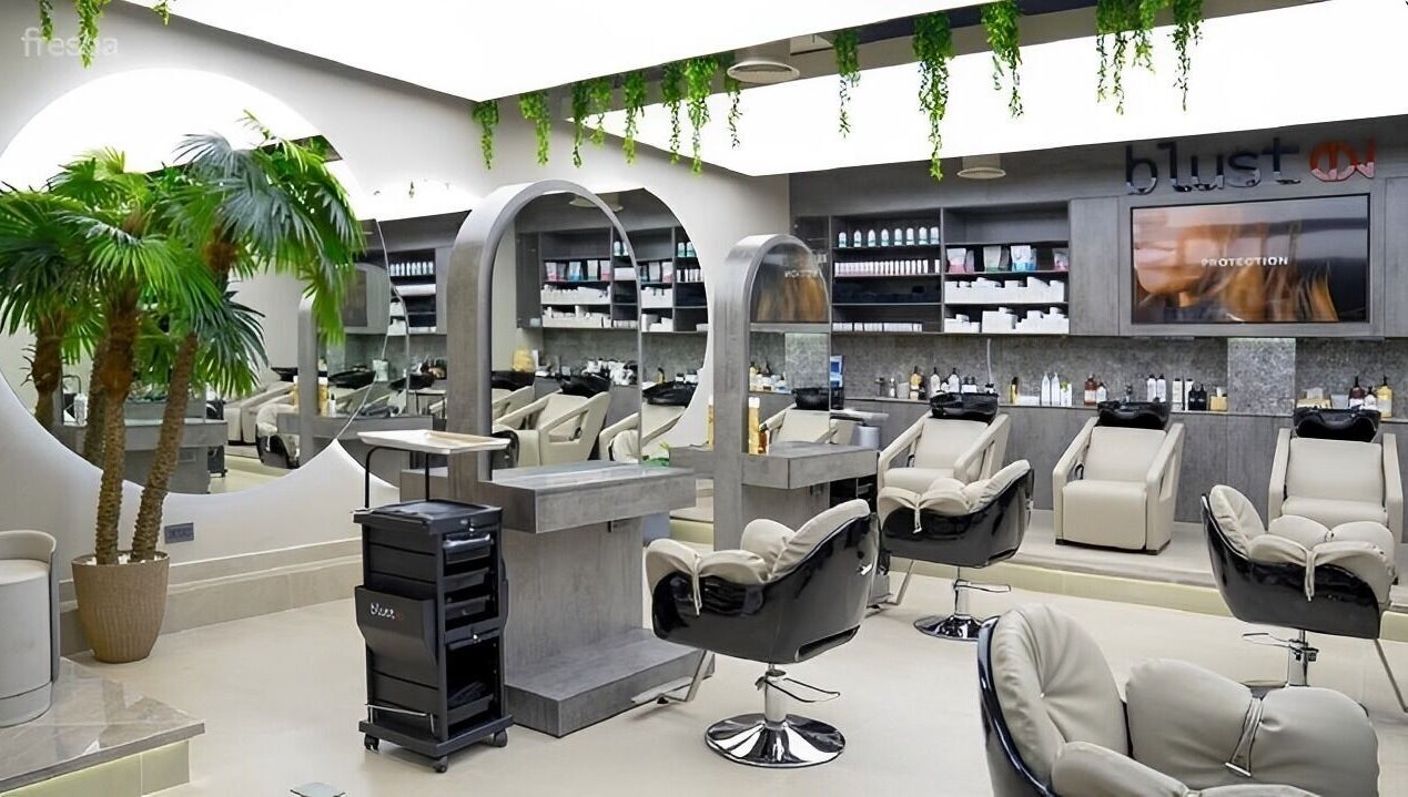 Modern salon interior at Victor Keyrouz X Amaraya, Dubai, AE, featuring sleek chairs and a large mirror.
