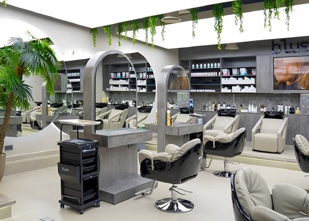 Modern salon interior at Victor Keyrouz X Amaraya, Dubai, AE, featuring sleek chairs and a large mirror.