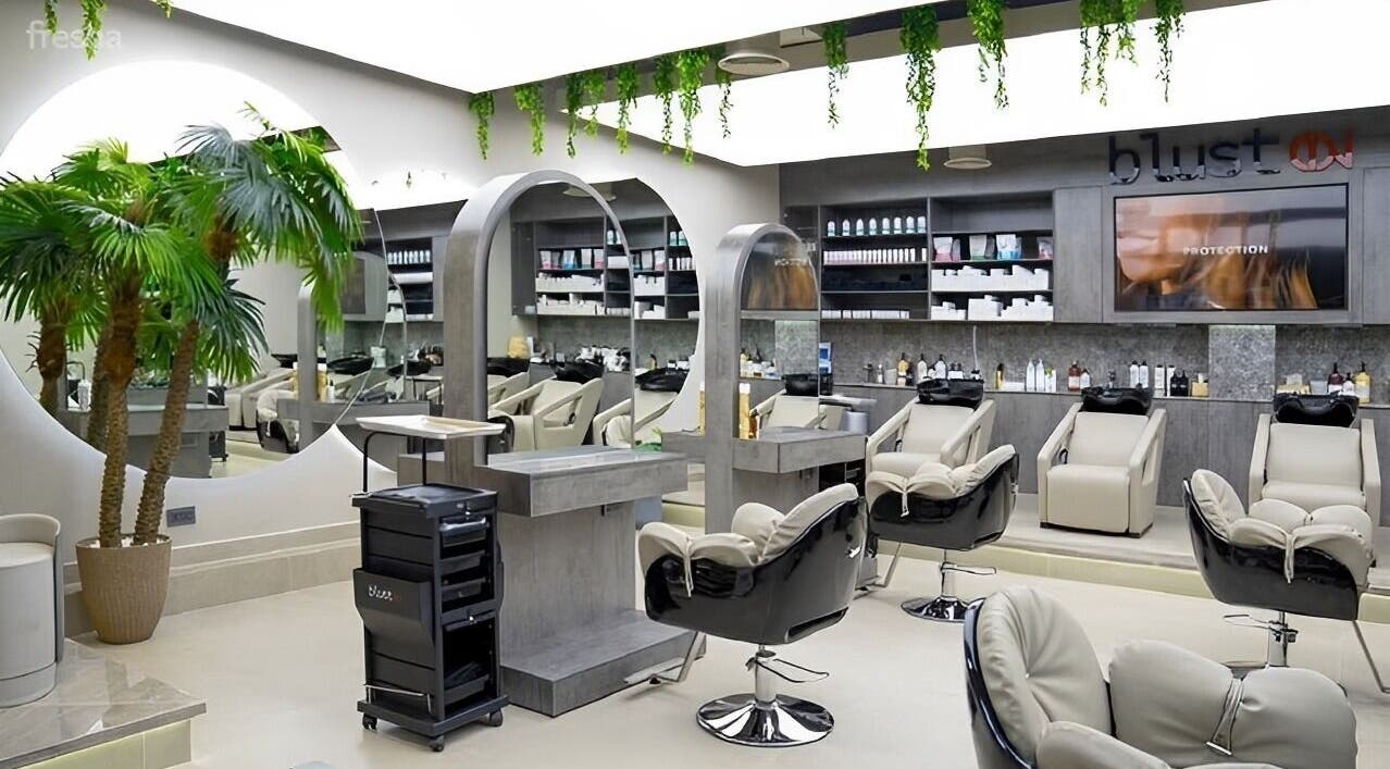 Modern salon interior at Victor Keyrouz X Amaraya, Dubai, AE, featuring sleek chairs and a large mirror.
