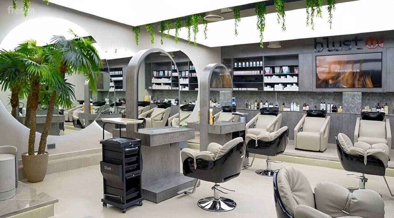 Modern salon interior at Victor Keyrouz X Amaraya, Dubai, AE, featuring sleek chairs and a large mirror.