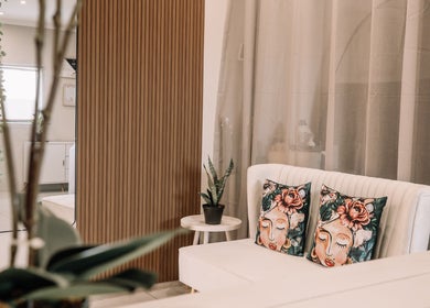 Chic seating area at Snatched Cosmetics, Boksburg, Gauteng, ZA with floral cushions and plant decor.