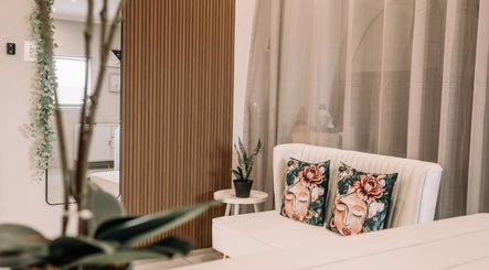 Chic seating area at Snatched Cosmetics, Boksburg, Gauteng, ZA with floral cushions and plant decor.