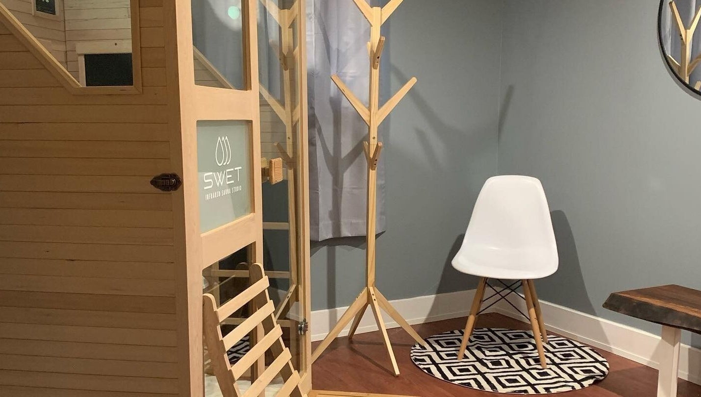 Cozy interior at SWET Infrared Sauna Studio - Forest Hills, Grand Rapids, Michigan, US with chair and wooden sauna.