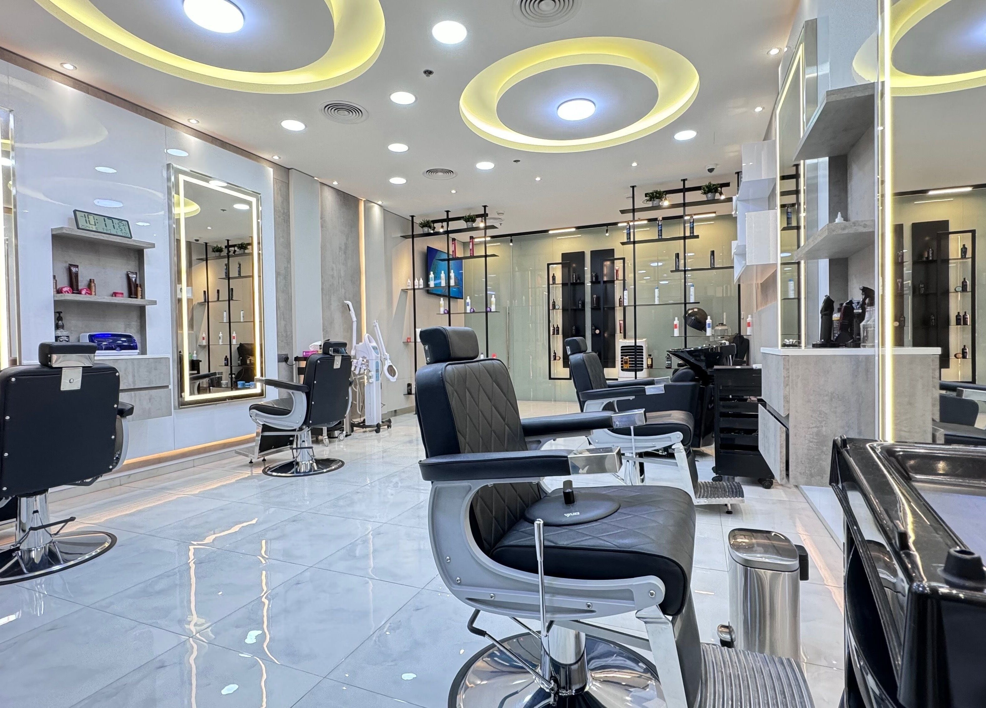 Bright, modern interior of Aleph Gents Salon DMCC in Dubai, AE with sleek black chairs and illuminated mirrors.