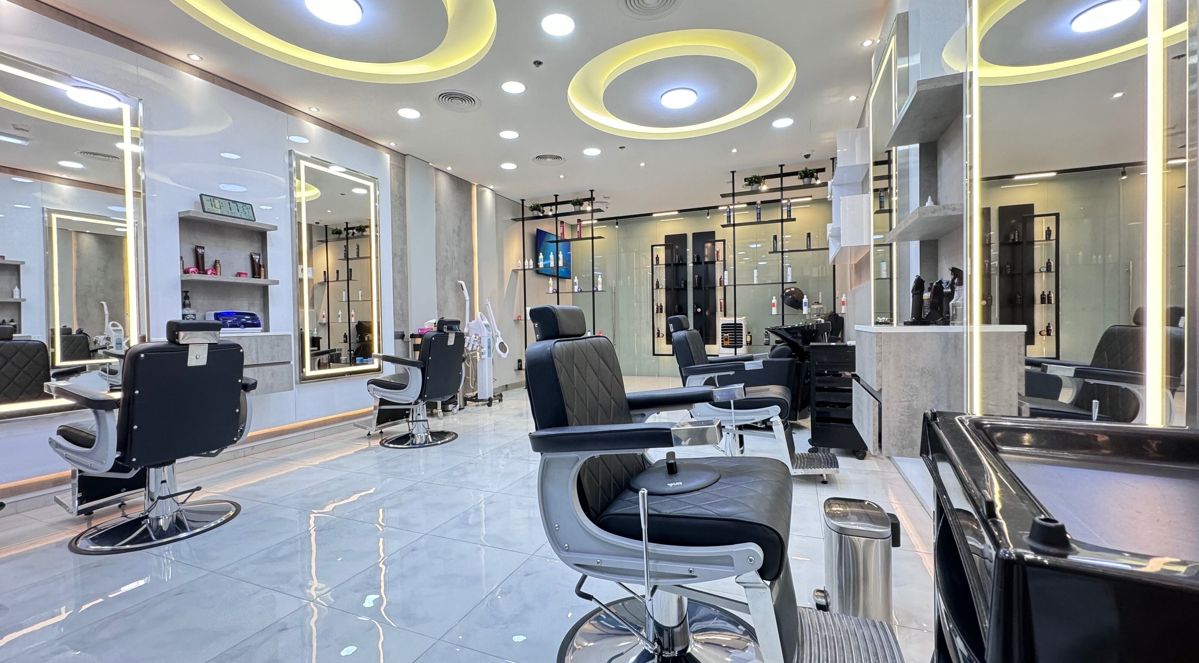 Bright, modern interior of Aleph Gents Salon DMCC in Dubai, AE with sleek black chairs and illuminated mirrors.