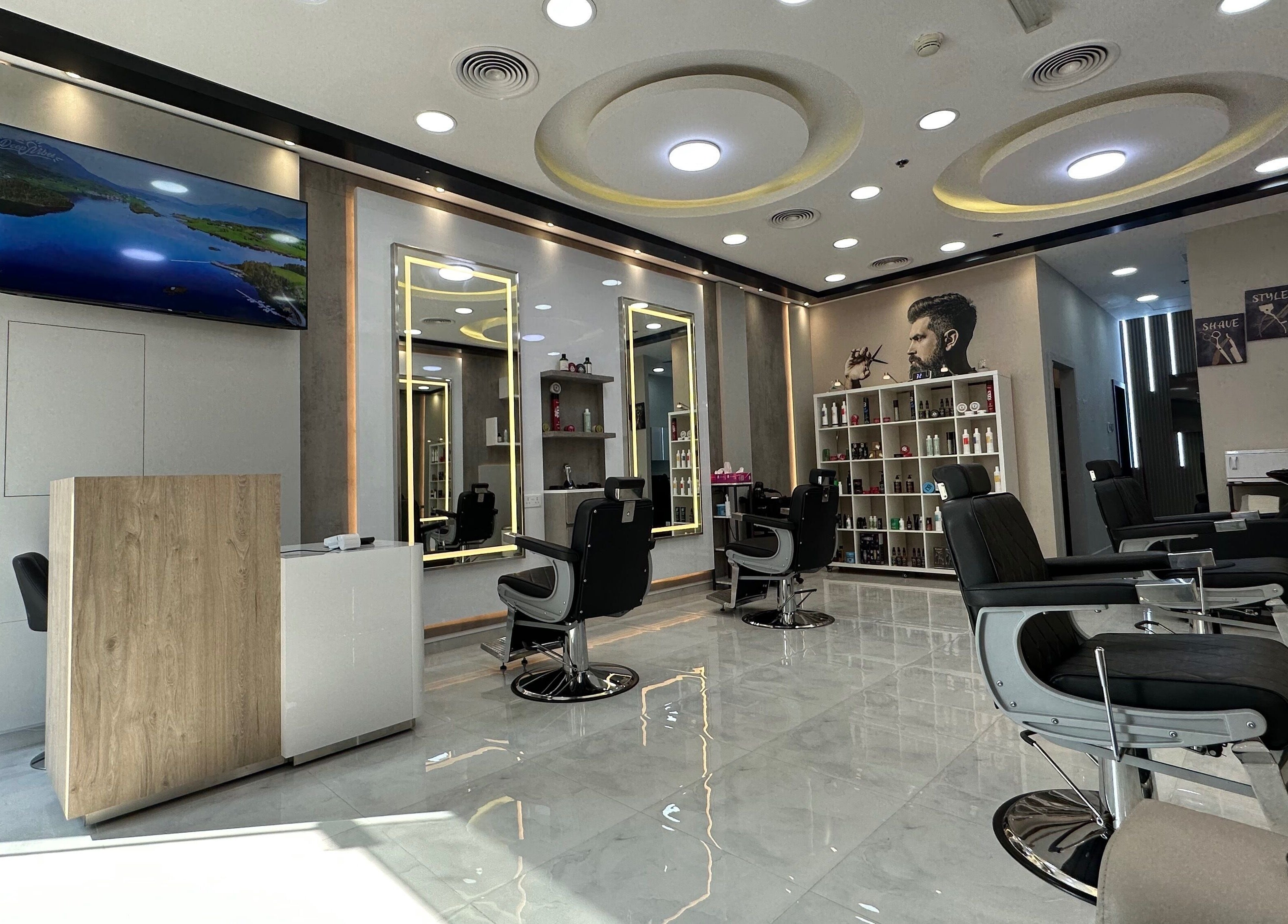 Modern interior of Aleph Gents Salon DMCC in Dubai, AE, with sleek barber chairs and vibrant lighting.