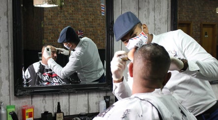 Barbeiro no The Friends - Barbershop em São Mamede de Infesta, Porto, PT, cuidando de um cliente.