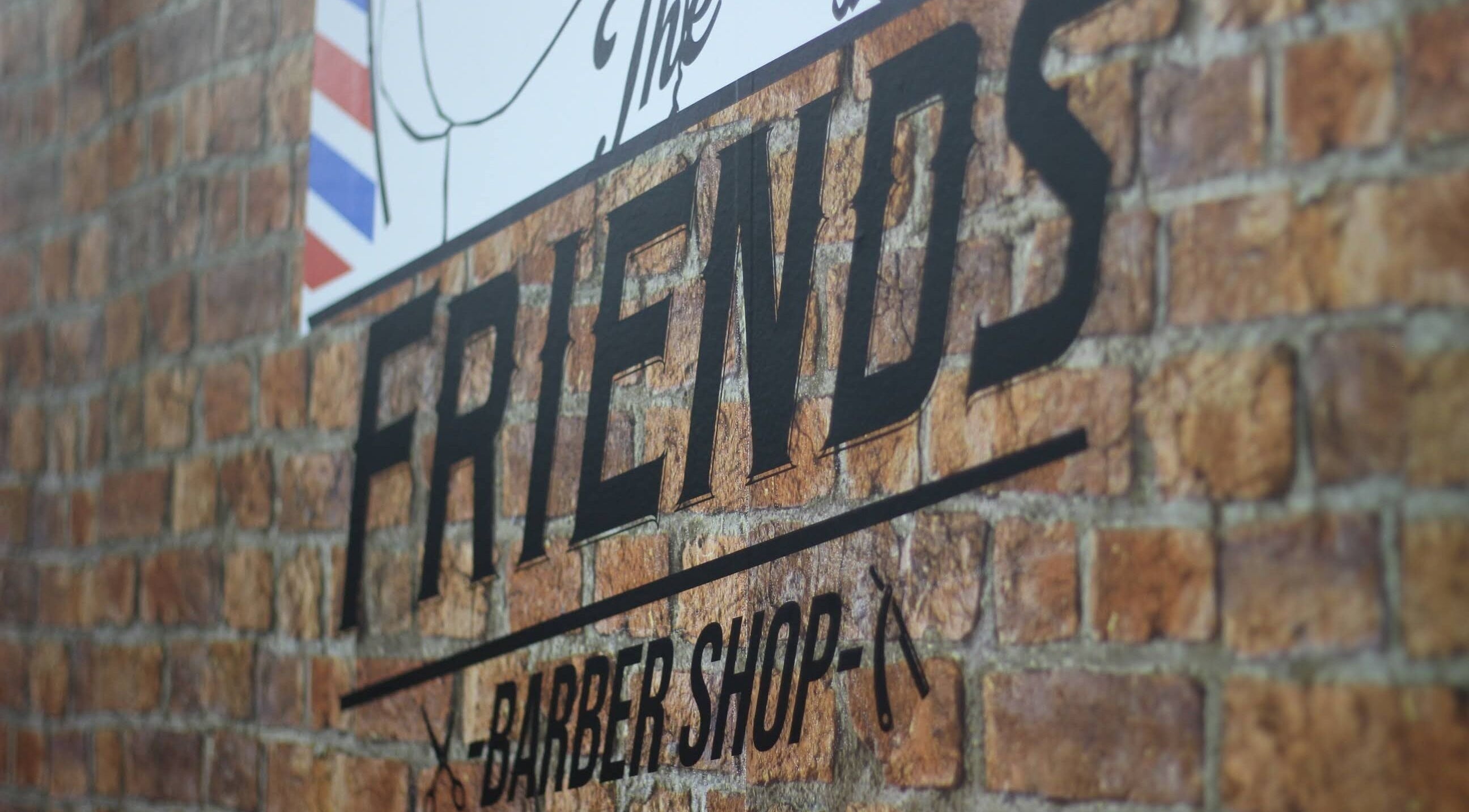 Logo da The Friends - Barber Shop em parede de tijolos, Porto, Porto, PT.