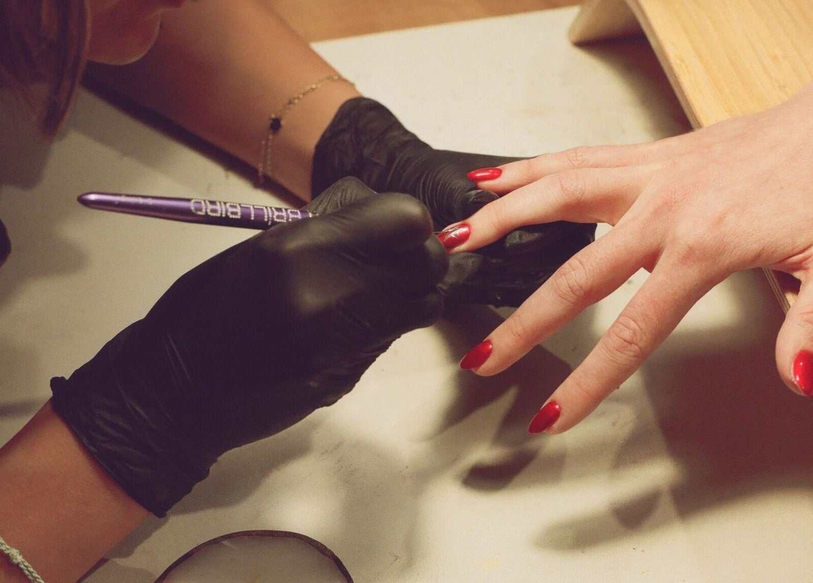 Nail artist painting red nails at Sun Day Studio, Truro, England, GB.