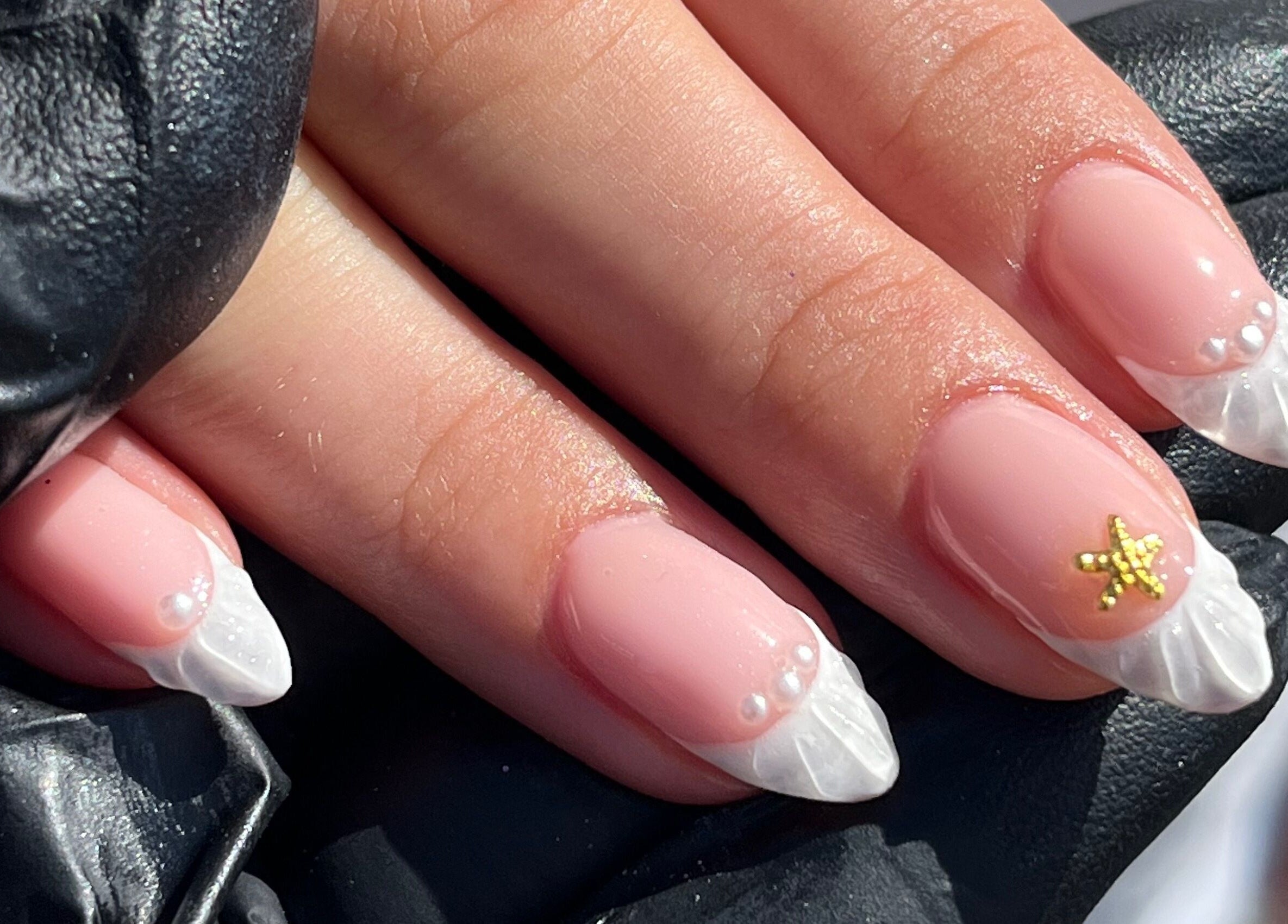 Nautical-themed manicure at Sun Day Studio, Truro, England, GB with pearl and star accents.