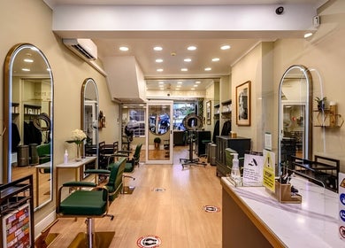Elegant interior of Mr M’s hair salon in London, England, GB with chic seating and large mirrors.