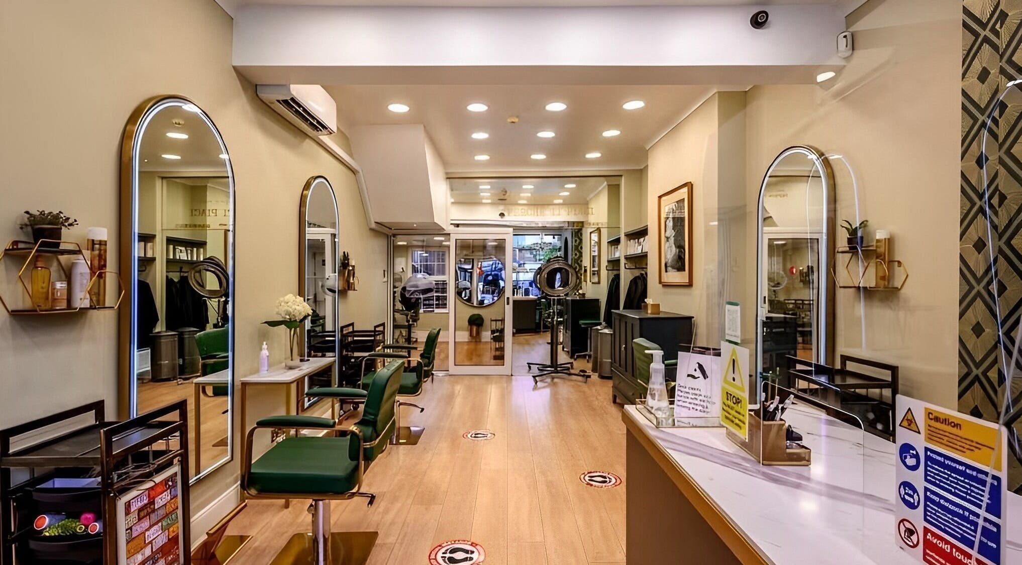 Elegant interior of Mr M’s hair salon in London, England, GB with chic seating and large mirrors.