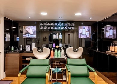 Chic salon interior at Mr M’s, London, England, GB showcasing modern hair wash stations and products.