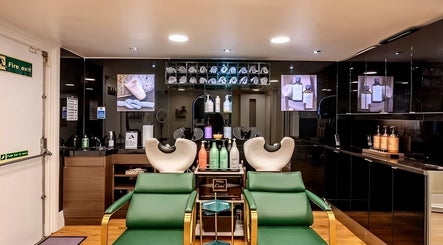 Chic salon interior at Mr M’s, London, England, GB showcasing modern hair wash stations and products.