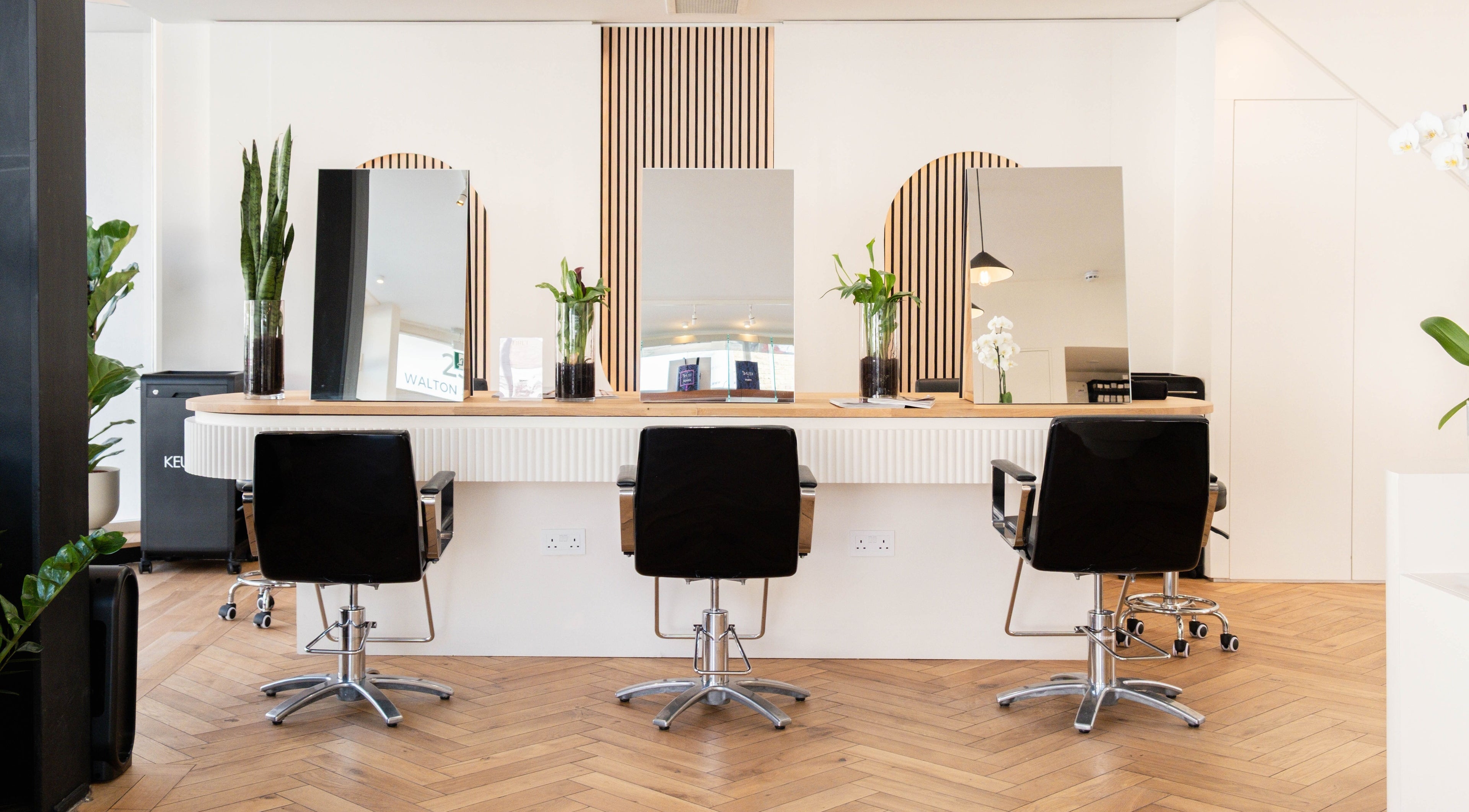 Modern salon station at Orel Hair and Beauty in London, England, GB, with chic design and mirrors.