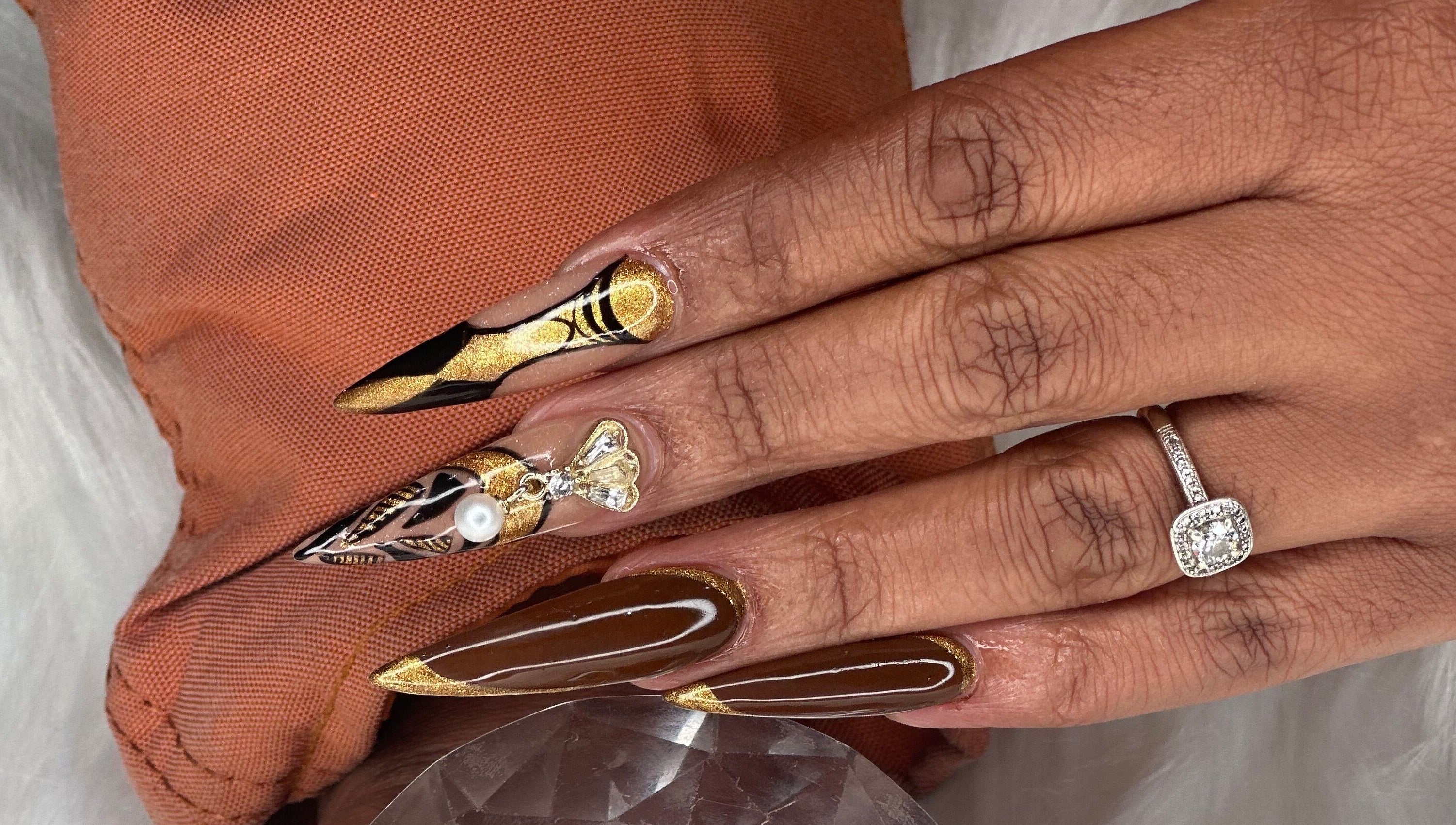 Intricate nail art with gold and pearl design at Elysian Escape Day Spa, Germiston, Gauteng, ZA.