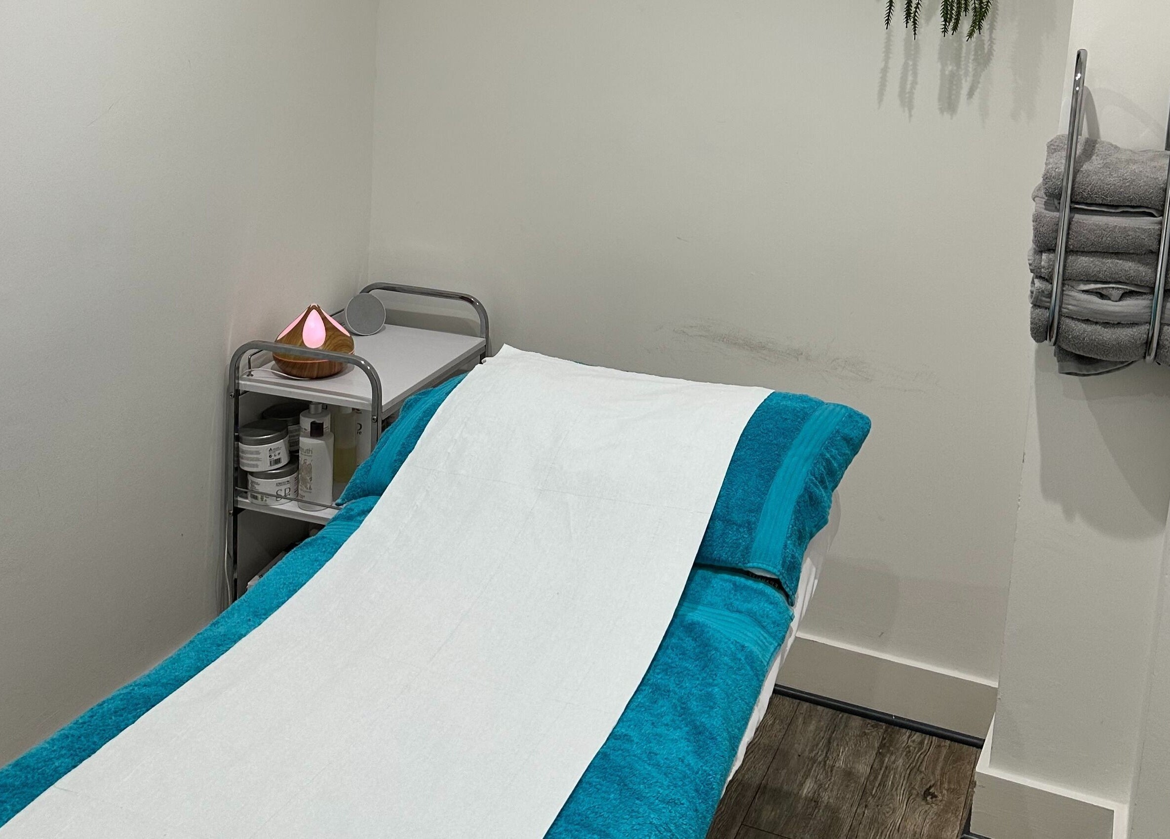 Cozy treatment room at The Cryo Lab in Whitefield, England, GB featuring a massage bed and relaxation essentials.