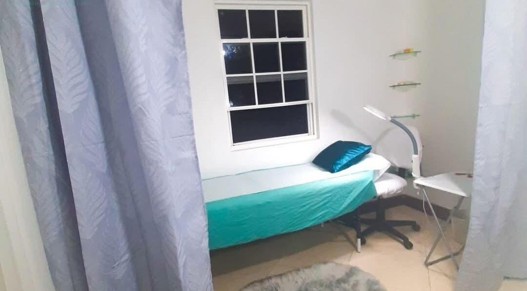 Relaxing treatment room at Eye Candy Beauty, Saint John, BB, featuring ambient lighting and a cozy bed.